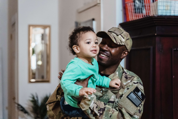 Man in military uniform holding his child